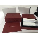 Two Cartier boxed cleaning kits complete with book