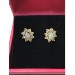 A pair of 9ct gold stud earrings set with a centra