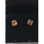 A pair of 9ct gold stud earrings set with orange z