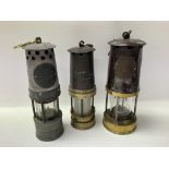 Three Davy safety lamps of varying sizes.