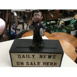 A small daily news advertisement figure on base.