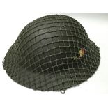 An army helmet covered in netting - NO RESERVE