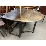 A dark stained oak folding dining table.