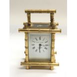 A small brass carriage clock with bamboo style dec