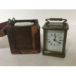 A small brass cased carriage clock in a traveling case with key seen working.