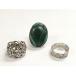 Three silver rings, one set with malachite.