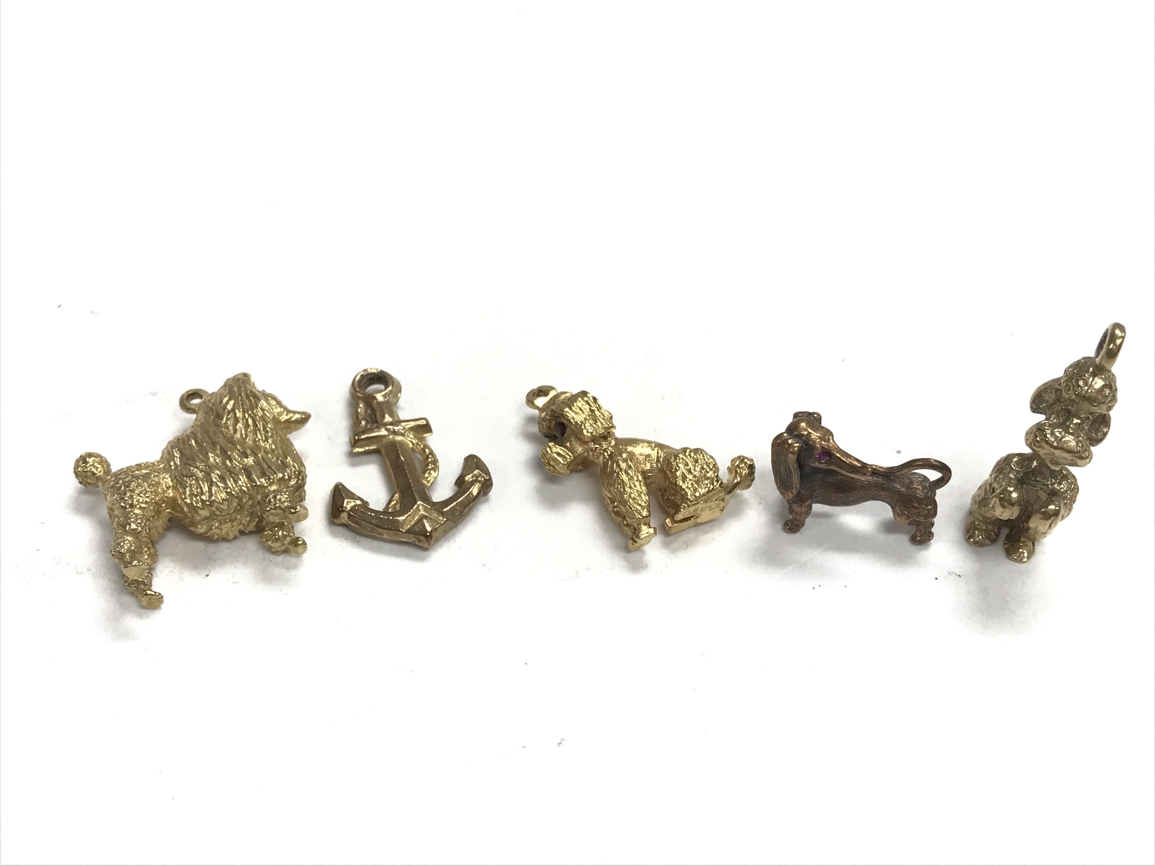 Five 9ct gold charms weighing approximately 24g.