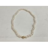 A string of small white cultured pearls fitted wit