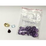 25 loose amethyst stones, a ruby, a topaz and a la
