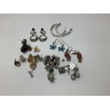 A collection of 19 pairs of silver earrings.