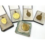 A collection of five gold medals awarded between 1