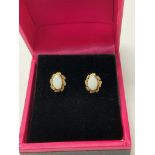 A pair of 9ct gold stud earrings set with white op