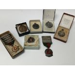A collection of medals, mostly silver and enamel.