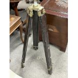 A vintage wooden and brass stand for a theodolite.