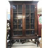 A mahogany two door display cabinet enclosing shelves on cabriole legs