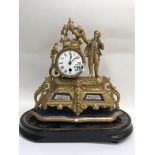 A gilt French mantle clock, the enamel dial with Roman numerals, flanked by a male figure. Inset