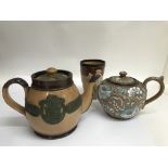 A Doulton stoneware teapot decorated with raised Maori style relief. Together with one other pot and