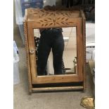 A hanging wall pine cabinet with a mirrored front.