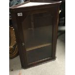 A Mahogany hanging cabinet with a glazed door.