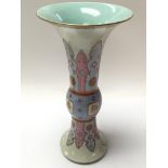 A trumpet shaped vase with oriental design on a wh