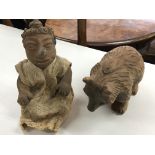 A carved wooden bear figure and a baked clay sculp