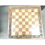 A chess table complete with chess pieces.