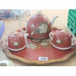 A Ceramic and painted metal tea set with tray no o