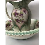 A jug and bowl decorated with flowers and foliage