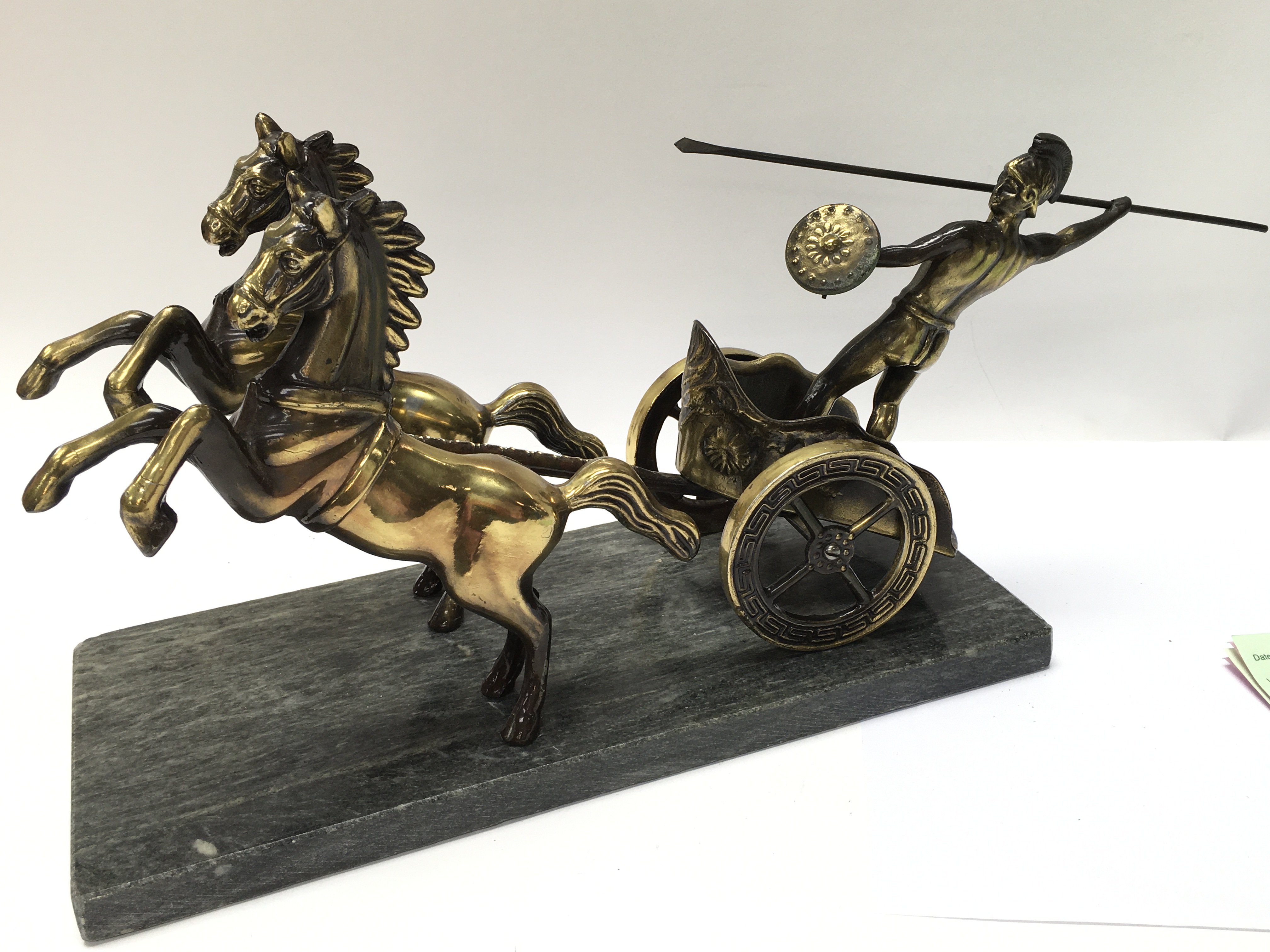 A heavy brass figure of a Roman chariot.