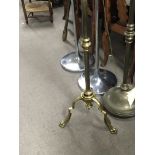 A brass telescopic standard lamp with shaped supports and claw feet.