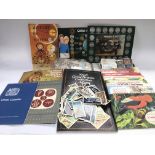 A collection of coins, stamps, books, cigarette an
