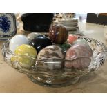 A glass bowl containing marble eggs various