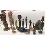 A collection of tourist tribal art wood and stone carvings and Indonesian wood carved figures.