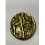 A brass oval, possibly a medal.
