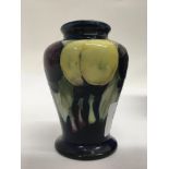 A small Moorcroft vase decorated with fruit on a b