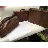 A leather Gladstone bag and two vintage leather su