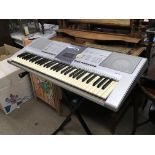 A Yamaha PSR electric piano on a folding stand.