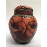 A small lidded Moorcroft vase decorated with poppi