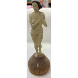 A modern design carved wooden nude lady on a circular basis, unattributed. The height is 37.5cm.