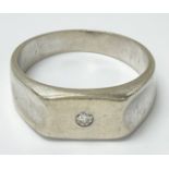 An unmarked white gold mens ring set with a singul