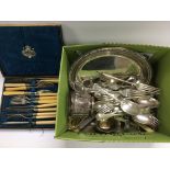 A box containing various silver plated items.