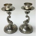 A pair of silver dolphin candlesticks, weighing ap