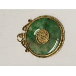 A Chinese jade pendant inset in an unmarked gold m