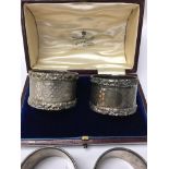 A cased pair of silver napkins two other silver na