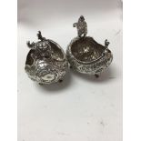 A pair of boat shaped silver salts with scrolled f