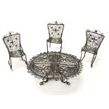 A silver filigree set of a table and three chairs.