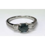 A teal sapphire and diamond trilogy ring with diam