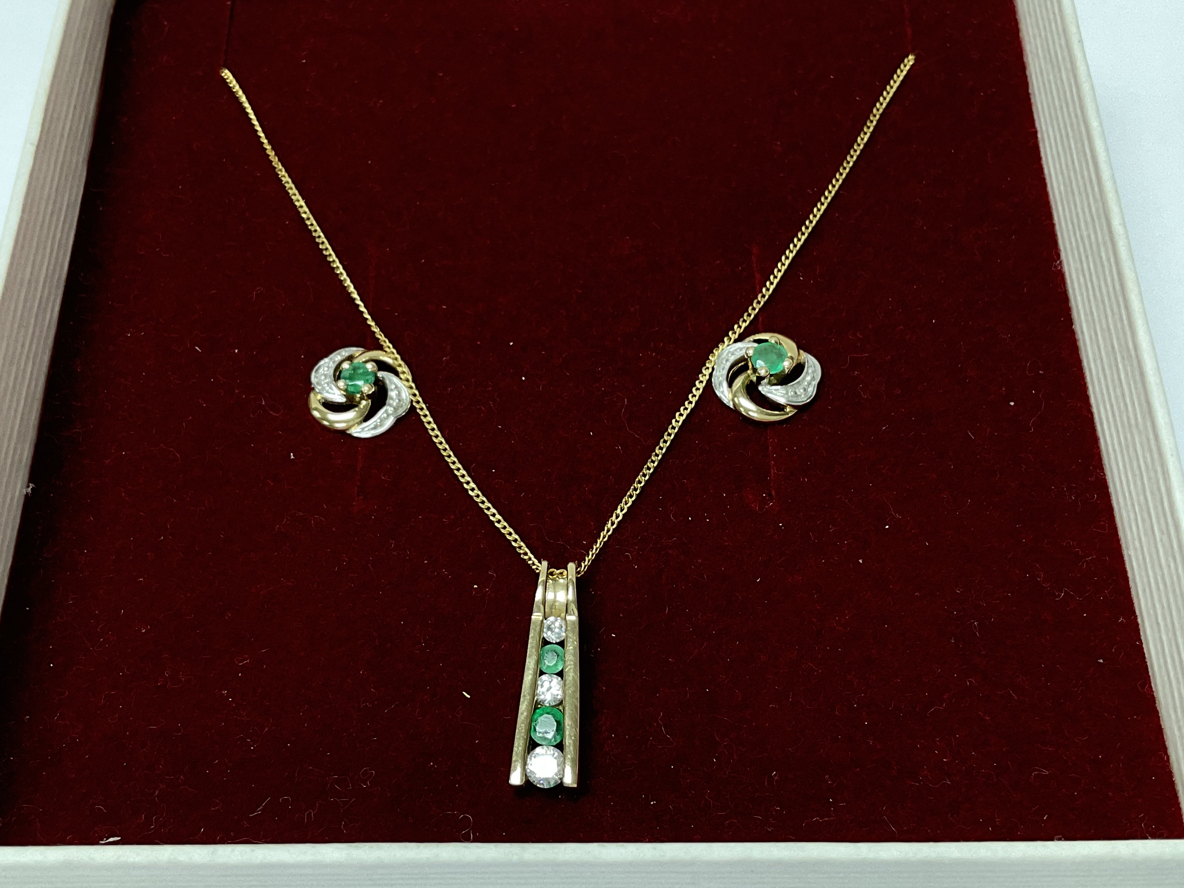 A 9ct gold pendant, chain and earrings set with em