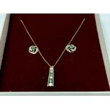 A 9ct gold pendant, chain and earrings set with em