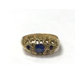 An 18ct gold ring set with three sapphires, the ri